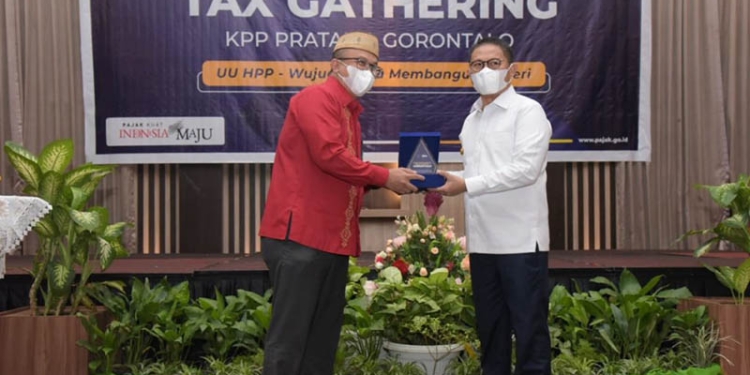 Penjabat Gubernur Gorontalo, Hamka Hendra Noer (kanan) menerima cinderamata dari Kepala KPP Pratama Gorontalo, Suyono.(Pemprov Gorontalo)