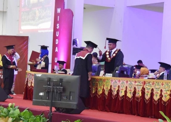 Rektor UNG, Eduart Wolok memindahkan tali toga lulusan UNG pada prosesi wisuda, Kamis (30/6/2022) (istimewa)