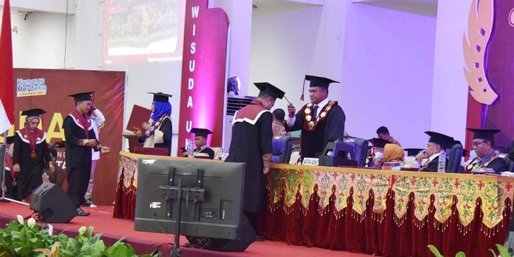 Rektor UNG, Eduart Wolok memindahkan tali toga lulusan UNG pada prosesi wisuda, Kamis (30/6/2022) (istimewa)