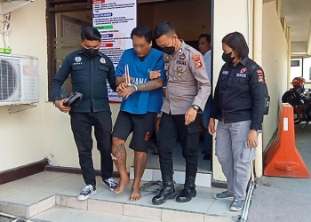 Tersangka pencurian sepeda motor, HW alias Gery dipapah personel Polres Gorontalo Kota. (Sari/gopos)