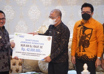 Wali Kota Gorontalo, Marten Taha, menyerahkan santunan Jamsostek untuk ahli waris ASN di Dinas PTSP Kota Gorontalo. (Pemkot Gorontalo)