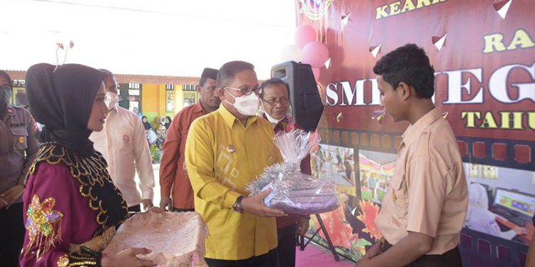 Wali Kota Gorontalo, Marten Taha, menyerahkan hadiah kepada siswa dalam kegiatan penamatan Siswa SMP 10 Kota Gorontalo, Kamis (23/6/2022). (Pemkot Gorontalo)