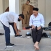 Bupati Hamim, Bupati Hamim Pou saat menyerahkan sepatu baru dan peralatan sekolah lainnya kepada Abdul Muzil Usuli sekaligus mengenakannya kepada siswa yang duduk di bangku SMP Negeri 3 Suwawa kelas VII itu, usai salat dzuhur di Masjid Agung Baitul Haq Islamic Center, Senin (6/6/2022). (Foto Indra/Gopos)