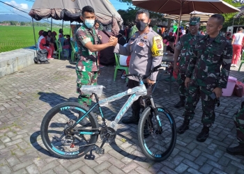 HUT Bhayangkara, Kapolres Bone Bolango, AKBP Emile Reisitei Hartanto saat menyerahkan hadiah utama satu unit sepeda kepada salah satu anggota TNI yang beruntung di HUT Bhayangkara ke-76, Jumat (17/6/2022). (Foto Indra/Gopos)