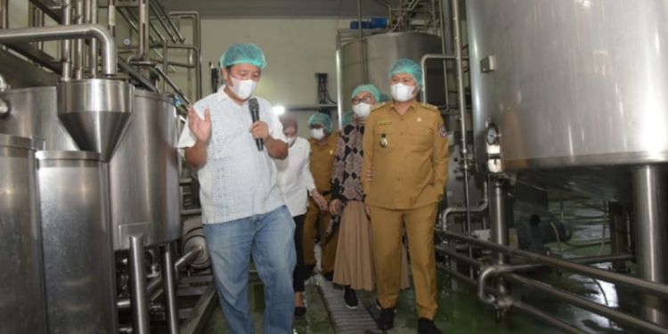 Penjagub Hamka didampingi istri drg. Gamariq Monoarfa saat meninjau proses produksi kelapa di PT Royal Coconut Gorontalo, Kabupaten Gorontalo, Senin (13/6/2022). Kelapa kelapa ini akan di ekspor ke negara negara tetangga dan Eropa.  (Foto: Salman)