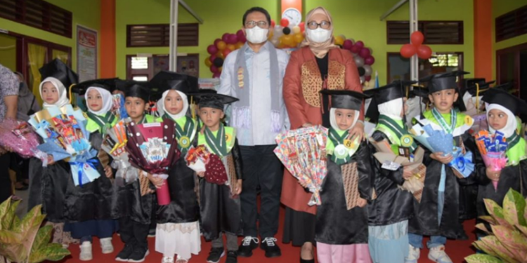 Penjagub Gorontalo Hamka Hendra Noer bersama Bunda PAUD Provinsi Gorontalo drg. Gamaria Monoarfa berfoto bersama wisudawan wisudawati Murid TK Marhama Angkatan IX Tahun Pelajaran 2021/2022 yang berlokasi di Desa Buhu, Kecamatan Telaga Jaya, Kabupaten Gorontalo, Selasa (28/6/202). (Foto: Salman)