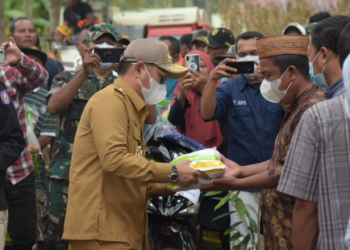 Penjagub Gorontalo, Hamka Hendra Noer saat menyerahkan bantuan pertanian kepada perwakilan petani di Kabupaten Gorontalo, Senin (13/06/22).