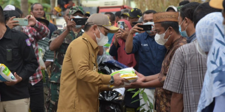 Penjagub Gorontalo, Hamka Hendra Noer saat menyerahkan bantuan pertanian kepada perwakilan petani di Kabupaten Gorontalo, Senin (13/06/22).
