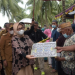 Ketua TPPKK drg. Gamaria saat turut menyerahkan bantuan pada masyarakat petani, Senin (13/06/2022).