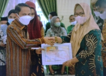 Bupati Gorontalo, Nelson Pomalingo saat memberikan penghargaan untuk salah satu Desa di Rapat Koordinasi Penetapan Hasil Pemutakhiran Data Indeks Desa Membangun (IDM) di Gedung Kasmat Lahay, Kabupaten Gorontalo, Selasa (5/7/2022). (Foto: Putra/Gopos)