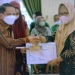 Bupati Gorontalo, Nelson Pomalingo saat memberikan penghargaan untuk salah satu Desa di Rapat Koordinasi Penetapan Hasil Pemutakhiran Data Indeks Desa Membangun (IDM) di Gedung Kasmat Lahay, Kabupaten Gorontalo, Selasa (5/7/2022). (Foto: Putra/Gopos)