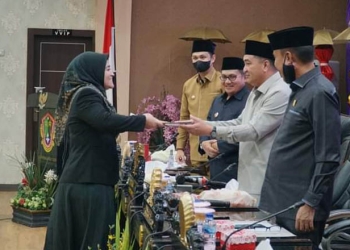 Anggota DPRD Kota Gorontalo Andi Helda Nyiwi, ketika menyerahkan  laporan badan anggaran kepada pimpinan rapat Paripurna tingkat dua tahap akhir penyampaian pendapat khir frkasi terhadap Ranperda tentang pertanggungjawaban pelaksanaan APBD Kota Gorontalo tahun anggaran 2021, , Senin (11/07/2022) malam.(Foto Humas)
