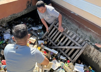 Kapolres Gorontalo Kota, AKBP Ardi Rahananto saat membersihkan tumpukan sampah di selokan, Kecamatan Kota Tengah, Kota Gorontalo. Jum'at (22/7/2022). Foto : humas