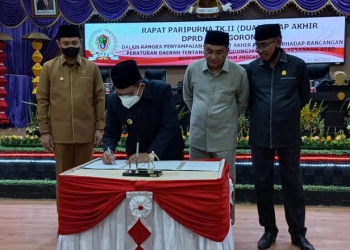 Wali Kota Gorontalo, Marten Taha, didampingi Wakil Wali Kota Gorontalo, Ryan F. Kono, menandatangani pengesahan Perda Pertanggungjawaban Pelaksanaan APBD Kota Gorontalo 2021, Senin (11/7/2022) di sidang paripurna DPRD Kota Gorontalo.(hasan/gopos)