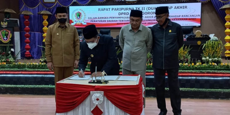 Wali Kota Gorontalo, Marten Taha, didampingi Wakil Wali Kota Gorontalo, Ryan F. Kono, menandatangani pengesahan Perda Pertanggungjawaban Pelaksanaan APBD Kota Gorontalo 2021, Senin (11/7/2022) di sidang paripurna DPRD Kota Gorontalo.(hasan/gopos)