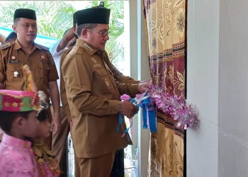 Wali Kota Gorontalo, Marten Taha, memotong pita menandai peresmian kantor Kelurahan Tanggikiki, Kecamatan Sipatana, Kota Gorontalo, Selasa (5/7/2022). (hasan/gopos)