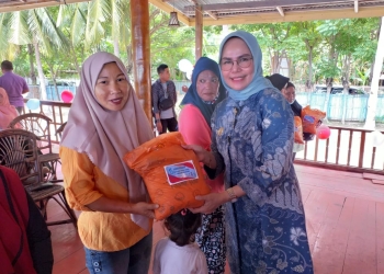 Wakil Bupati Bone Bolango Merlan S. Uloli saat menyerahkan paket bantuan maupun bingkisan pada Hari Ulang Tahun PKH yang ke-15 di Pantai Exotic Kecamatan Kabila Bone, Kamis (28/7/2022). (Foto Indra/Gopos)