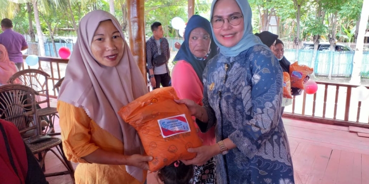 Wakil Bupati Bone Bolango Merlan S. Uloli saat menyerahkan paket bantuan maupun bingkisan pada Hari Ulang Tahun PKH yang ke-15 di Pantai Exotic Kecamatan Kabila Bone, Kamis (28/7/2022). (Foto Indra/Gopos)