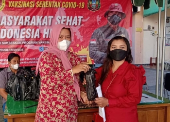 Masyarakat yang menerima minyak goreng usai disuntikkan vaksin. (Foto: dok. BINDA Jatim)