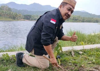 Ketua Dewan Perwakilan Rakyat Daerah (DPRD) Kabupaten Bone Bolango, Halid Tangahu saat melakukan penanaman bibit pohon di Danau Perintis. (Foto: Putra/Gopos)