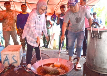 Wabup Merlan turut berbaur dengan para relawan untuk memasak makanan untuk warga terdampak banjir. Tak canggung, Wakil Bupati perempuan pertama di Bone Bolango itu memperlihatkan kelihaiannya dalam menggoreng ikan dan memasak nasi, di posko dapur umum, di halaman Kantor Desa Masiaga, Kamis (24/8/2022). (Foto AKP/Diskominfo)