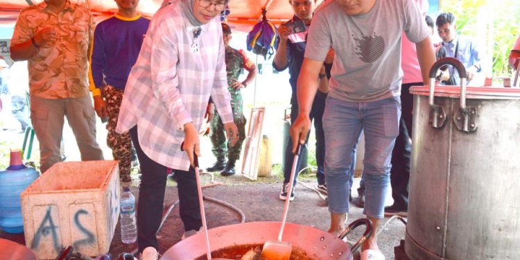 Wabup Merlan turut berbaur dengan para relawan untuk memasak makanan untuk warga terdampak banjir. Tak canggung, Wakil Bupati perempuan pertama di Bone Bolango itu memperlihatkan kelihaiannya dalam menggoreng ikan dan memasak nasi, di posko dapur umum, di halaman Kantor Desa Masiaga, Kamis (24/8/2022). (Foto AKP/Diskominfo)