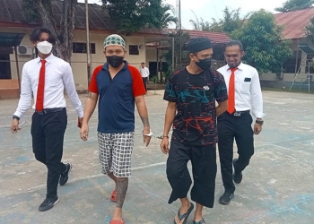 Terduga pelaku AP dan MK digiring personil Polres Gorontalo, Senin (15/8/2022). (Foto: Sari/gopos)