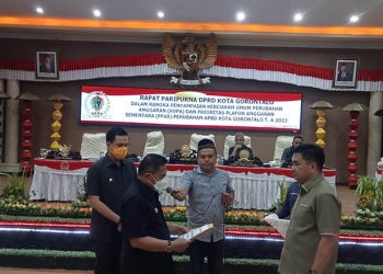 Wali Kota Gorontalo, Marten Taha menyerahkan perubahan anggaran dan prioritas plafon anggaran sementara, anggaran pendapatan belanja daerah Kota Gorontalo, tahun anggaran 2022, kepada Ketua DPRD Kota Gorontalo, Hardi Sidiki. Jum'at (12/8/2022). Foto : Sari/gopos