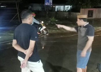 Aleg Dekot Gorontalo, Herman Haluti saat meninjau lokasi genangan di jalan Palma, Kecamatan Dungingi, Kota Gorontalo, Selasa malam (30/8/2022). Foto: istimewa