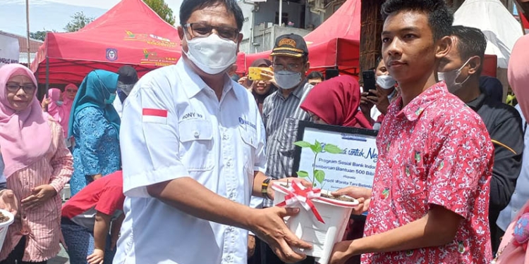 Kepala Perwakilan BI Gorontalo, Ronny Widijarto Purubaskoro (kiri) menyerahkan secara simbolis benih cabai kepada kelompok siswa dalam peluncuran Gerakan Masyarakat Batanam Rica Sandiri (Germas Batari) di Kelurahan Ipilo, Kota Timur, Kota Gorontalo, Sabtu (13/8/2022). (hasan/gopos)