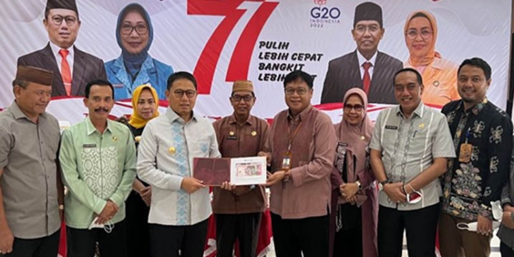 Kepala Perwakilan Bank Indonesia (BI) Gorontalo, Rony Widijarto Purubaskoro (kemeja merah maron), menyerahkan Token of Apreciation (Toa) uang kertas Rupiah Tahun Emisi 2022 kepada Pj Gubernur Gorontalo, Hamka Hendra Noer, usai mengikuti peluncuran   uang kertas TE 2022 secara daring di rumah dinas Gubernur Gorontalo, Kamis (18/8/2022). (Humas BI Gorontalo)
