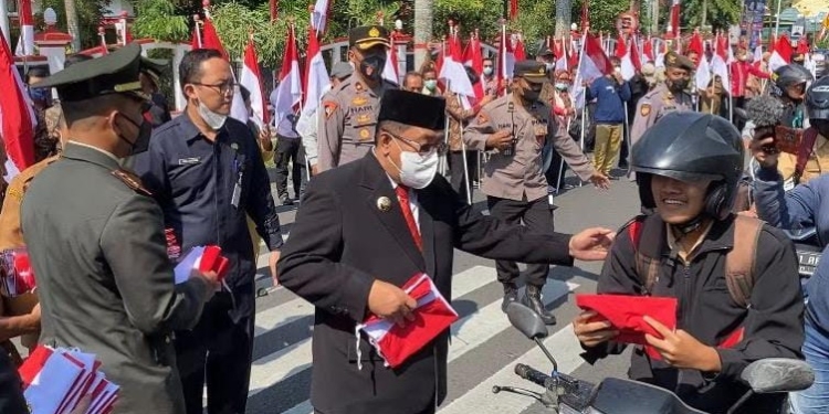 Wali Kota Blitar, Santoso saat membagikan bendera di Jalan Ahmad Yani, Kota Blitar, Senin (15/8/2022). (foto: Pemkot Blitar)