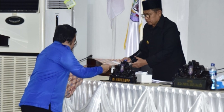 Juru bicara Fraksi Demokrat Erwin Ismail (kiri) menyerahkan dokumen pemandangan umum fraksi terhadap APBD Perubahan Provinsi Gorontalo kepada Penjabat Gubernur Gorontalo Hamka Hendra Noer (kanan) pada Sidang Paripurna DPRD Provinsi Gorontalo ke 93 dalam rangka Dengar Pendapat Akhir Fraksi terhadap Rencana Peraturan Daerah APBD Perubahan, Senin (19/9/2022). Foto: Nova