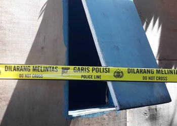 Polisi memasang garis polisi pada jendela rumah milik HM, petani di Randangan yang ditemukan tewas gantung diri, Sabtu (10/9/2022)