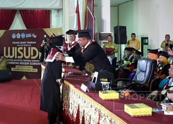 Momen haru ketika Rektor UNG, Eduar Wolok memindai tali toga Kurnia Heremba S.KM, wisudawati yang orang tuanya meninggal jelang wisuda, Rabu (28/9/2022) (Tangkapan Layar Yotube UNG TV)