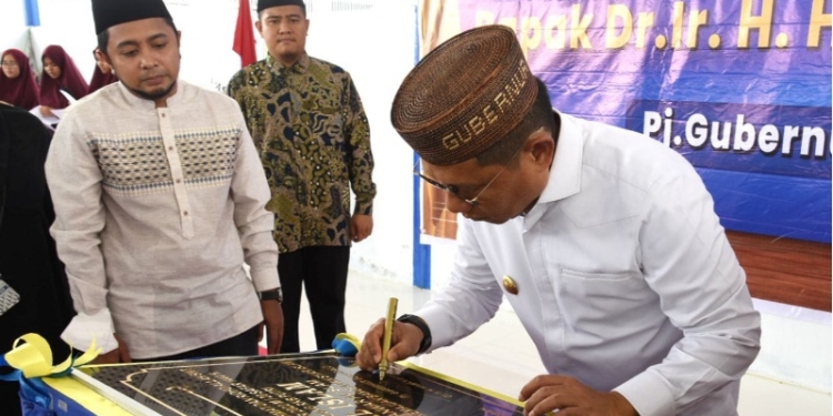 Penjagub Gorontalo, Hamka Hendra Noer (kanan), menandatangani prasasti peresmian RKB santri putri Pesantren Al-Islam di Kecamatan Telaga Biru, Kabupaten Gorontalo, Jumat (16/9/2022). (Foto: Haris/Hms)