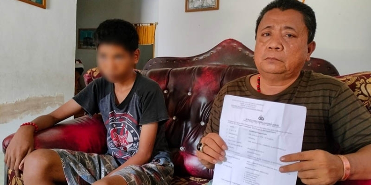 Orang tua siswa, TMRA, menunjukkan laporan kepolisian yang disampaikan terkait dugaan pengeroyokan enam orang siswa kepada anaknya, Jumat (23/9/2022) (putra/gopos)