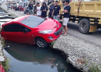 Mobil Mazda berwarna merah dievakuasi dari lokasi kejadian di Jl. Nani Wartabone (eks Jl. Panjaitan, Kota Gorontalo). (istimewa)