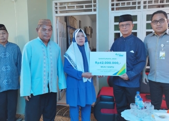 Sekda Ishak Ntoma, selaku Ketua Dewan Pengurus Korpri Bone Bolango didampingi Kabid Kepesertaan BPJS Ketenagakerjaan Cabang Gorontalo Riyan Umar, menyerahkan santunan JKM kepada Pahita, selaku istri atau ahli waris dari almarhum Mun Yantu, anggota Korpri Bone Bolango, pada acara doa arwah ke-40 hari di Kelurahan Tumbihe, Kecamatan Kabila, Selasa (27/9/2022). (Foto AKP/Diskominfo)