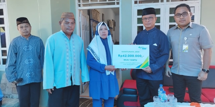Sekda Ishak Ntoma, selaku Ketua Dewan Pengurus Korpri Bone Bolango didampingi Kabid Kepesertaan BPJS Ketenagakerjaan Cabang Gorontalo Riyan Umar, menyerahkan santunan JKM kepada Pahita, selaku istri atau ahli waris dari almarhum Mun Yantu, anggota Korpri Bone Bolango, pada acara doa arwah ke-40 hari di Kelurahan Tumbihe, Kecamatan Kabila, Selasa (27/9/2022). (Foto AKP/Diskominfo)