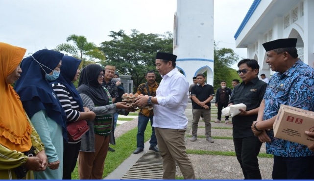 Bupati Hamim Pou menyerahkan secara simbolis bantuan stabilitasi pasokan dan harga pangan tahun 2022, kepada perwakilan pedagang kios di wilayah Kecamatan Kabila dan Tilongkabila, di halaman Masjid Agung Baitul Haq Islamic Center Bone Bolango, Jumat (15/7/2022). (Foto AKP/Diskominfo)