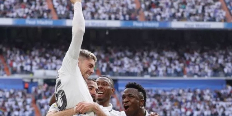 Gelandang Real Madrid, Fede Valverde (atas) melakukan selebrasi usai mencetak gol ke gawang Barcelona pada laga Liga Spanyol di Santiago Bernabeu, Minggu (16/10/2022) malam WIB. [THOMAS COEX / AFP]