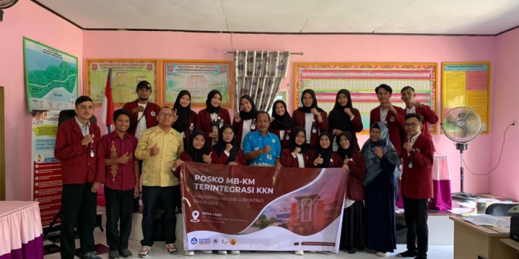 16 mahasiswa Prpgram Studi Statistika UNG saat foto bersama dengan Kepala Desa Tihu, Harun Tahidji dan Ketua Tim Dosen Pembing Lapangan KKN MBKM UNG Novianita Achmad di Kantor Desa Tihu, Selasa (4/10/2022)