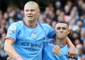 Penyerang Manchester City, Erling Haaland (kiri) dan gelandang serang Phil Foden merayakan gol ke gawang Manchester United pada laga Liga Inggris di Stadion Etihad, Manchester, Minggu (2/10/2022) malam WIB. [AFP/Suara.com]