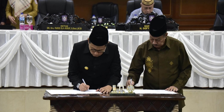 Penjabat Gubernur Gorontalo Hamka Hendra Noer (kiri) bersama Ketua DPRD Provinsi Gorontalo Paris RA Jusuf menandatangani berita acara persetujuan Rencana Peraturan Daerah (Ranperda) Anggaran Pendapatan dan Belanja Daerah (APBD) tahun 2023 untuk ditetapkan menjadi Perda. Persetujuan diambil melalui Rapat Paripurna ke-97 Pembicaraan Tingkat II terhadap Ranperda APBD, yang berlangsung di ruang rapat DPRD, Senin malam (24/10/2022). (Kominfo Gorontalo)