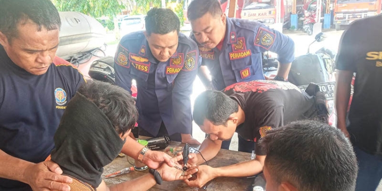Petugas Pemadam Kebakaran Kota Gorontalo mengeluarkan cincin yang sulit dilepaskan dari jari Ismail Lamata, Rabu (19/10/2022).(Istimewa)