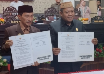 Bupati Gorontalo, Nelson Pomalingo (kiri), Ketua DPRD Kabupaten Gorontalo, Syam T Ase (kanan) saat memperlihatkan hasil pemandangan Nota Kesepakatan APBD-P Kabupaten Gorontalo. (Foto: Putra/Gopos)
