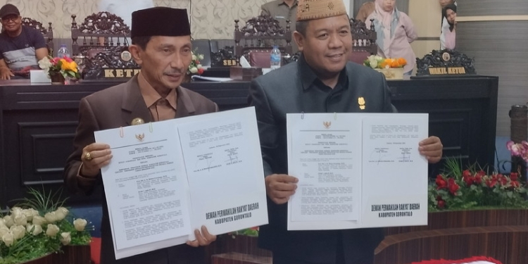 Bupati Gorontalo, Nelson Pomalingo (kiri), Ketua DPRD Kabupaten Gorontalo, Syam T Ase (kanan) saat memperlihatkan hasil pemandangan Nota Kesepakatan APBD-P Kabupaten Gorontalo. (Foto: Putra/Gopos)