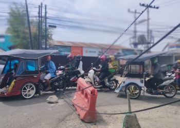 Kabel di pertigaan Kompleks Poltekes Gorontalo sebabkan kemacetan beberapa kenderaan yang melintas, Ahad (23/10/2022). (Foto: Putra/Gopos)