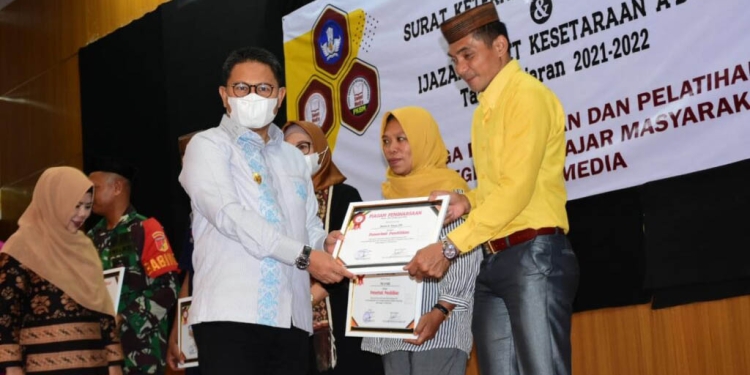 Penjagub Hamka Hendra Noer saat menyerahkan ijazah kepada perwakilan warga putus sekolah yang berhasil menyelesaikan belajar mengajar pada Pusat Kegiatan Belajar Mengajar (PKBM) Sweet Media berupa ijazah paket a b c, Sabtu (15/10/2022). (Kominfo Gorontalo)